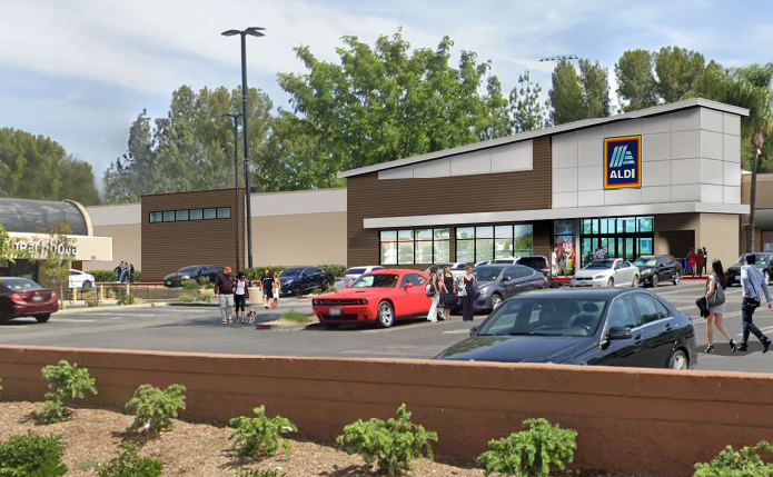 Rendering of Aldi store with trees in background and parking lot and shrubs in foreground.