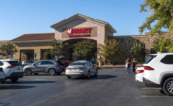 H Mart storefront facing parking lot with a tree on the right.