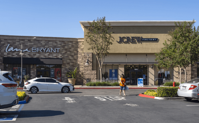 J Crew Factory storefront with white car and customer approaching.
