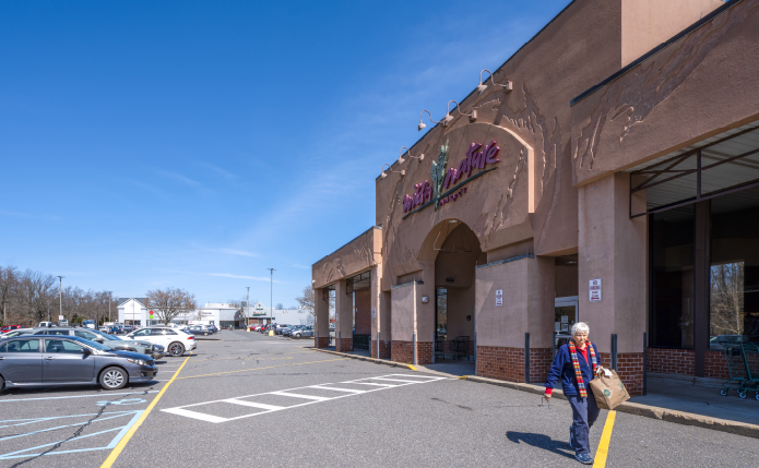 Shopper with bag leaving Wild By Nature grocery store