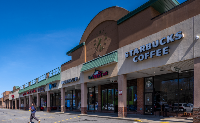 Woman exits Starbucks Coffee into parking lot