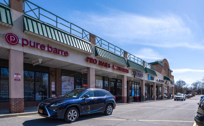 SUV passes Pure Barre on access road at West Center.