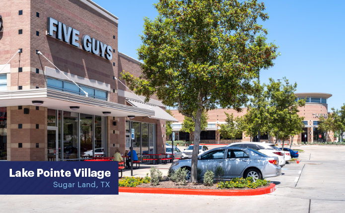 Trees and parking lot in front of Five Guys restaurant