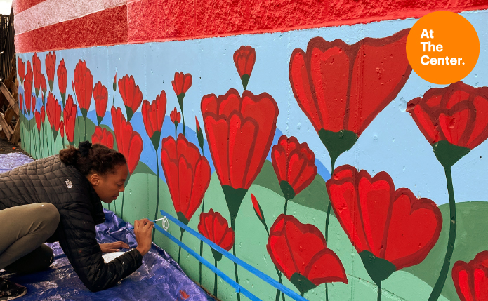 Woman painting mural at Shoppes at Vestal