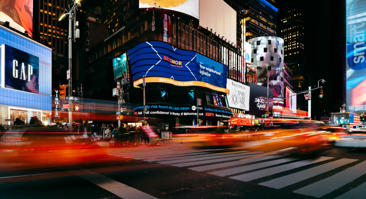 Brixmor billboard at Times Square with blur of cars passing by.