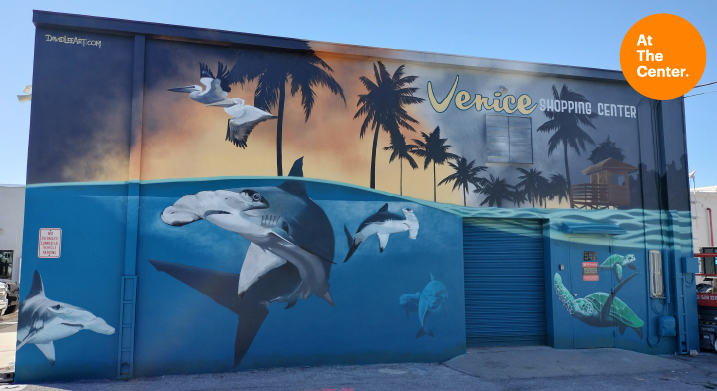 Mural of ocean scene with sharks, turtles, palm trees and pelicans.