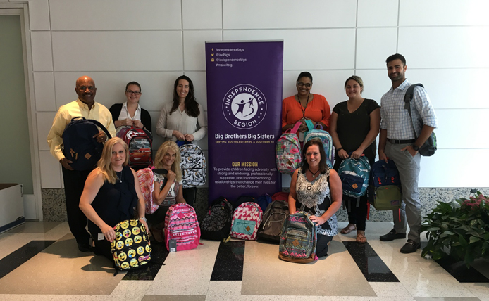 Brixmor employees at Big Brother Big Sister holding backpacks