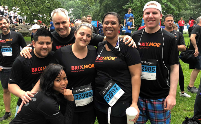 Group of brixmor employees at a running event with company tshirts on