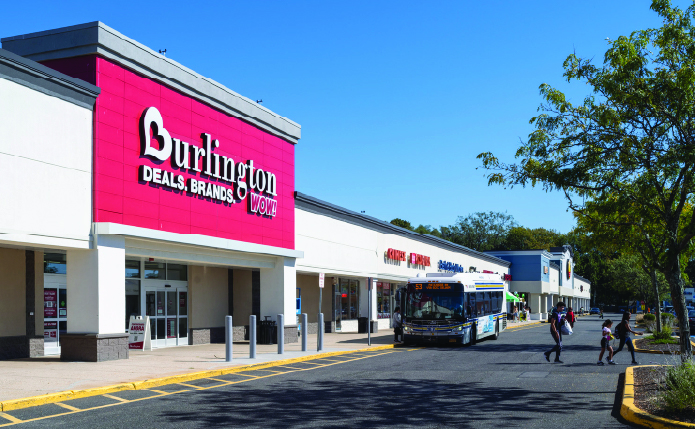 Burlington storefront with bus and customers in cross-walk.
