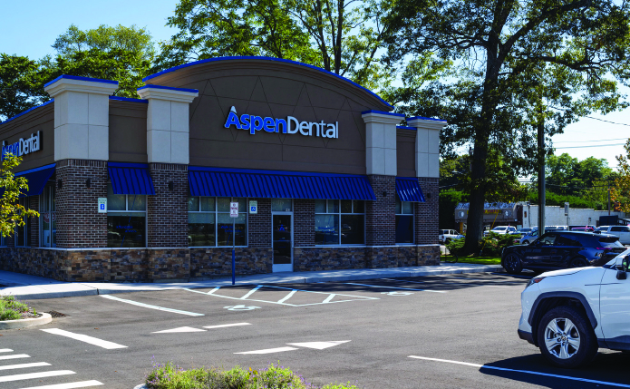 Aspen Dental and parking lot with white car.
