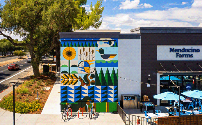 Mendocino Farms with large tree and mural on side.