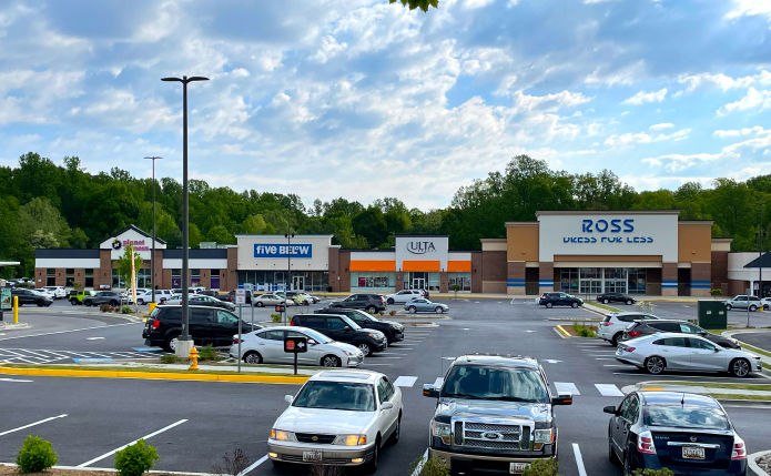 Parking lot and blue cloudy sky over Ross, Ulta, Five Below and Planet Fitness stores.