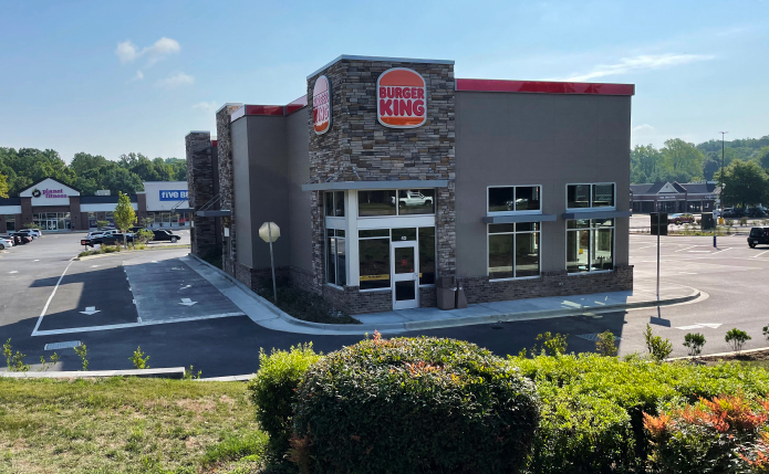 Burger King store with bushes and drive-through in front.