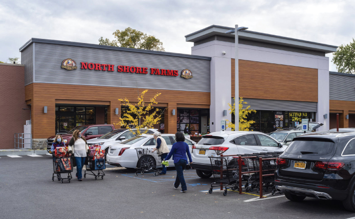 People with shopping carts walking towards North Shore Farms at Mamaroneck Centre in Mamaroneck, New York