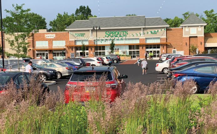 Green plants in front of full parking lot at Sprouts Farmers Market at Marlton Crossing shopping center