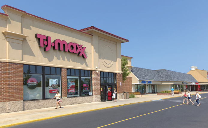 People walking towards entrance of T.J. Maxx on a clear day at outdoor shopping center in Marlton, New Jersey