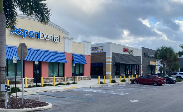 Aspen Dental with palm tree in left foreground.