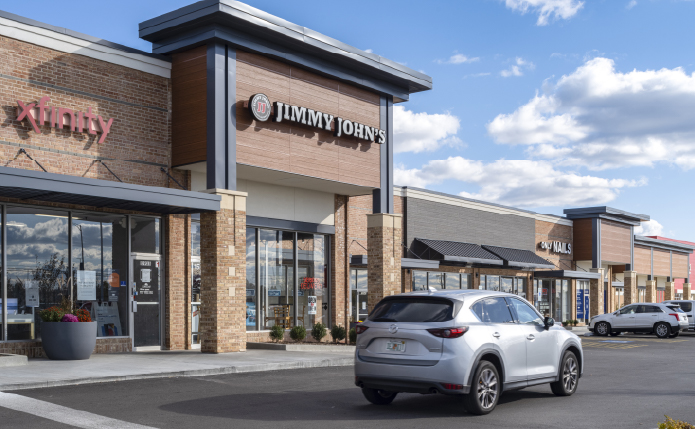 Grey SUV passing Jimmy John's store.