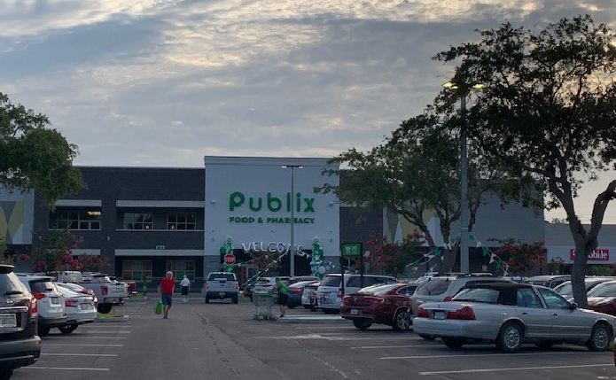 Publix with pedestrians in buys parking lot in front.