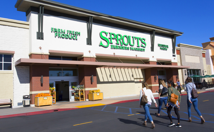 Pedestrians walking towards Sprouts Farmers Market.