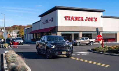Trader Joe’s at Middletown Plaza in Middletown, NJ, featuring a clean modern façade with bold red signage, large front windows, surrounding parking area, and landscaped edges under a bright clear sky.