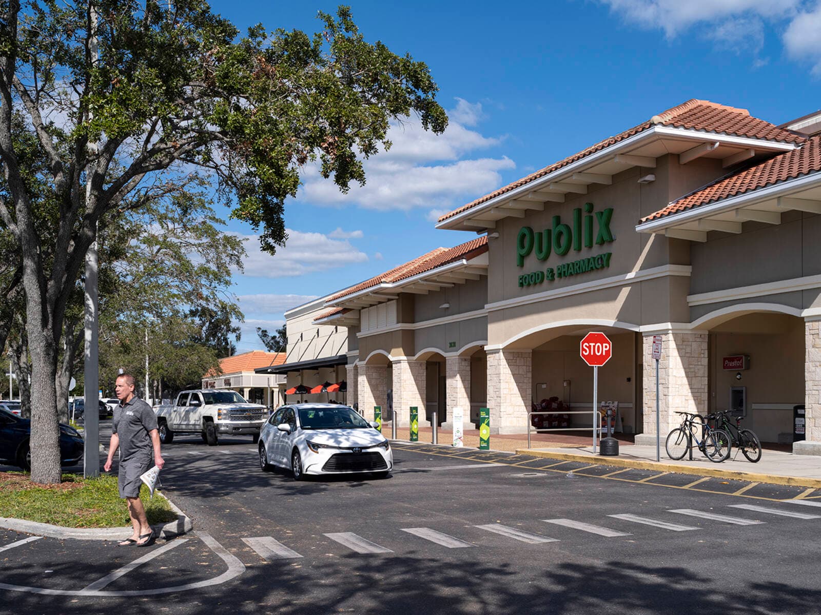 Entrance to Publix with cars and people.