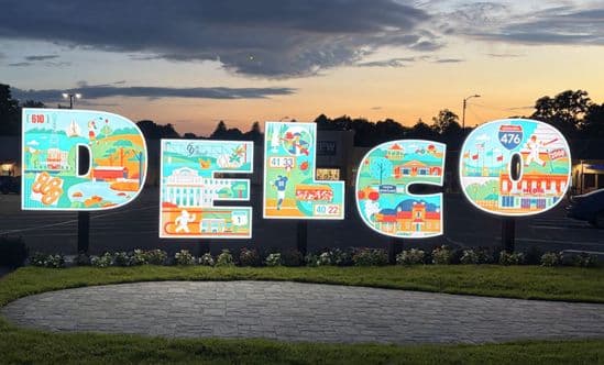 Delco sign at Pilgrim Gardens at sunset.