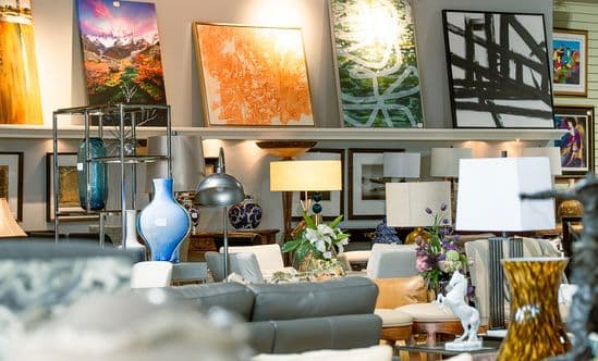 Interior of a furniture store with a chair, paintings and lamps in view