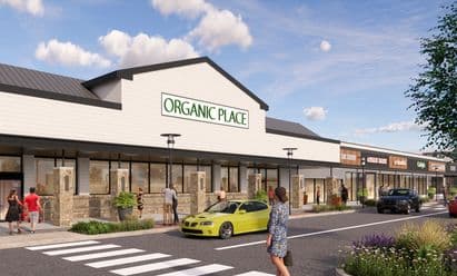 Rendering of the redeveloped Morris Hills Shopping Center featuring a grocer and a modernized retail streetscape with enhanced storefronts, upgraded façades, landscaping, pedestrian crosswalks, outdoor lighting, and convenient parking.
