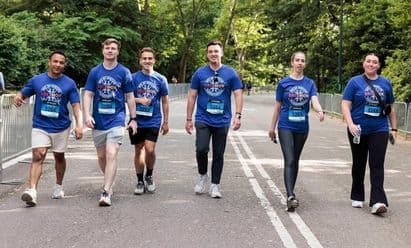 Group of employees in Brixmor shirts and race numbers walking on an outdoor road