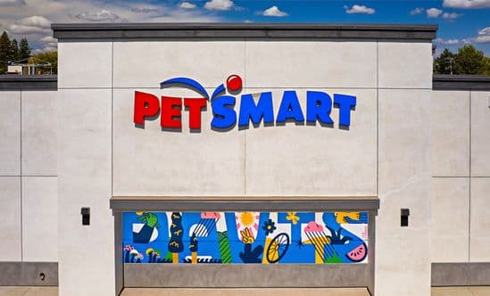 PetSmart at The Davis Collection in Davis, CA, shown with a clean white exterior, bold multicolor signage, and a vibrant mural panel along the base of the storefront featuring abstract animal and floral artwork beneath a bright daytime sky.”