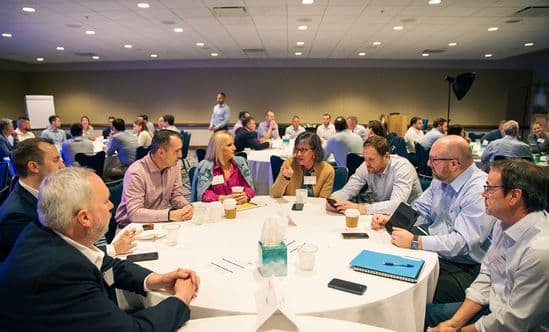 group of Brixmor leaders sitting and talking around a round table with white tablecloth 