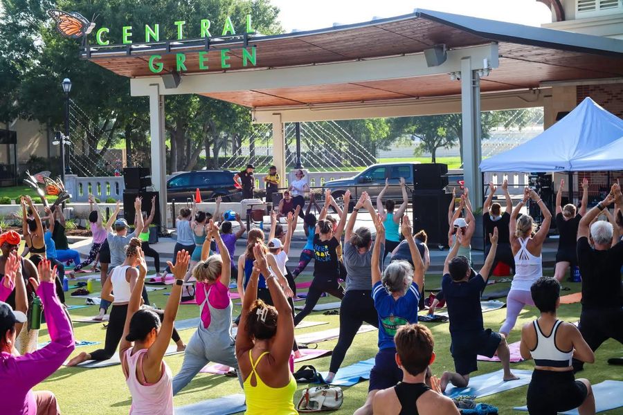 Large group of people doing yoga in Central Green at LaCenterra at Cinco Ranch in Houston area