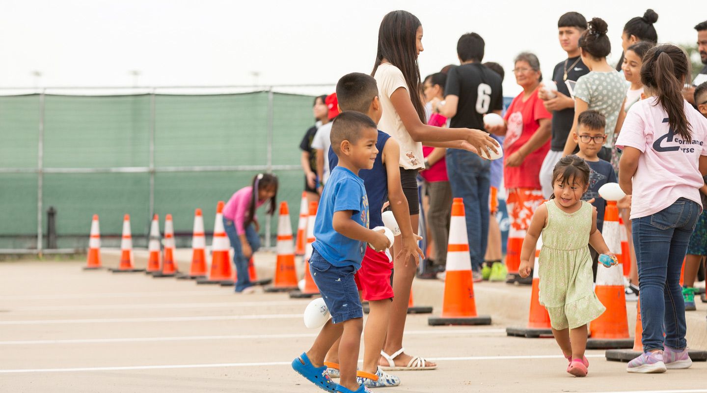 Group of adults and kids at a parking lot event