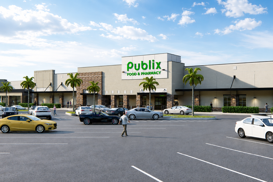 Updated grocery‑anchored retail building at Sunrise Town Center in Sunrise, FL, shown with stone accent columns, wide sidewalks, palm‑lined frontage, and customer vehicles filling the surrounding parking area.