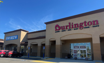 Burlington and Five Below at Vail Ranch Center in Temecula, CA, shown with warm earth‑tone architectural finishes, prominent red and blue signage, wide pedestrian walkways, and a partially filled parking lot beneath clear sunny skies.
