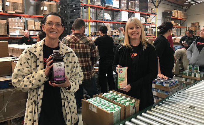 Two Brixmor volunteers on a packing line at food bank