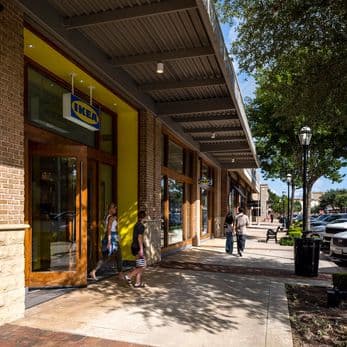 2 customers exit IKEA while 2 adults walk down the sidewalk at LaCenterra at Cinco Ranch.