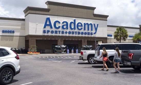 Customers approach Academy Sports through the parking lot.