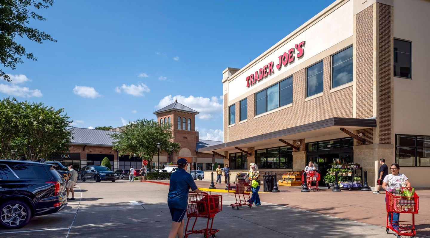 Patrons with shopping carts enter and exit Trader Joe's at LaCenterra at Cinco Ranch.